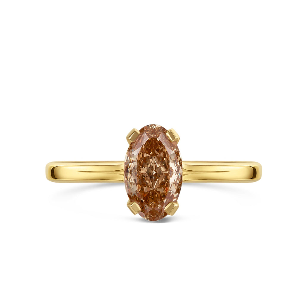 Gold ring with a brown oval diamond on a white background