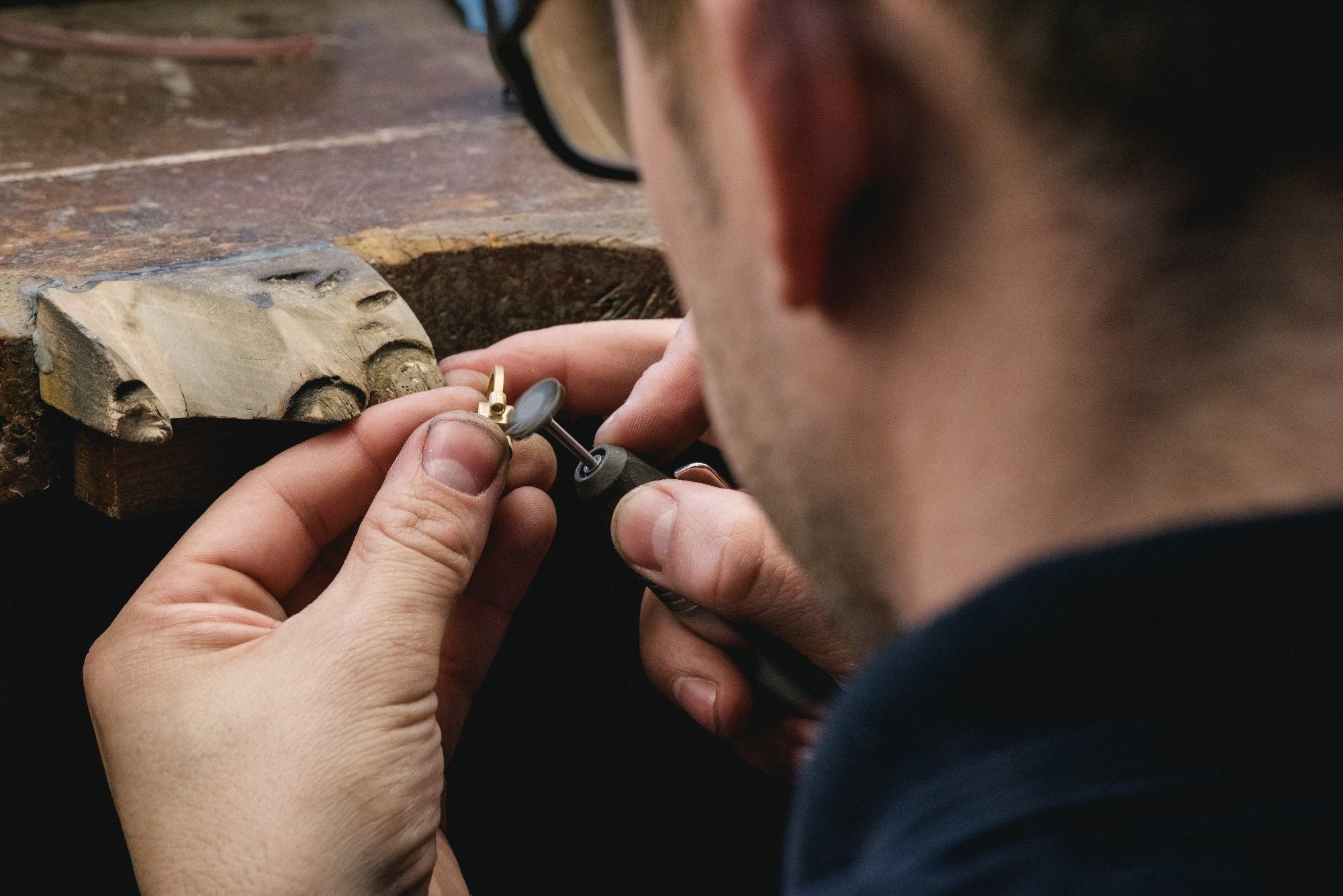 Person working with a small tool making an engagement ring on a bench peg