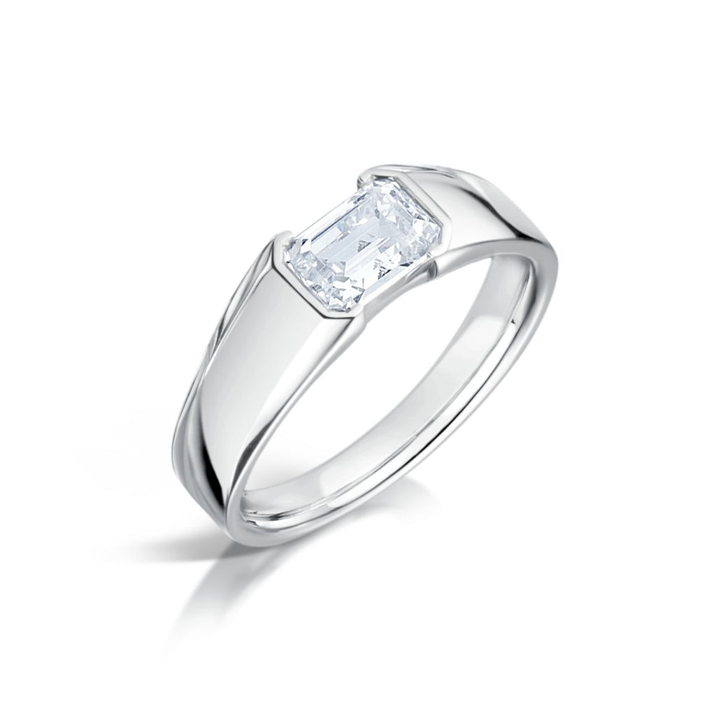 A chunky emerald cut diamond engagement ring with a platinum band, displayed against a white background.