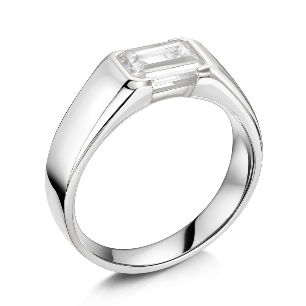 Chunky platinum emerald cut diamond east west diamond ring - angled on a white background 