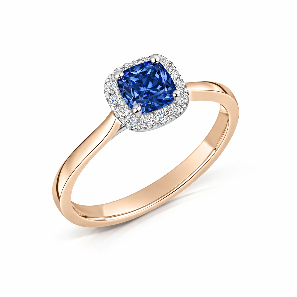 blue sapphire with diamond halo engagement ring in rose gold on a white background