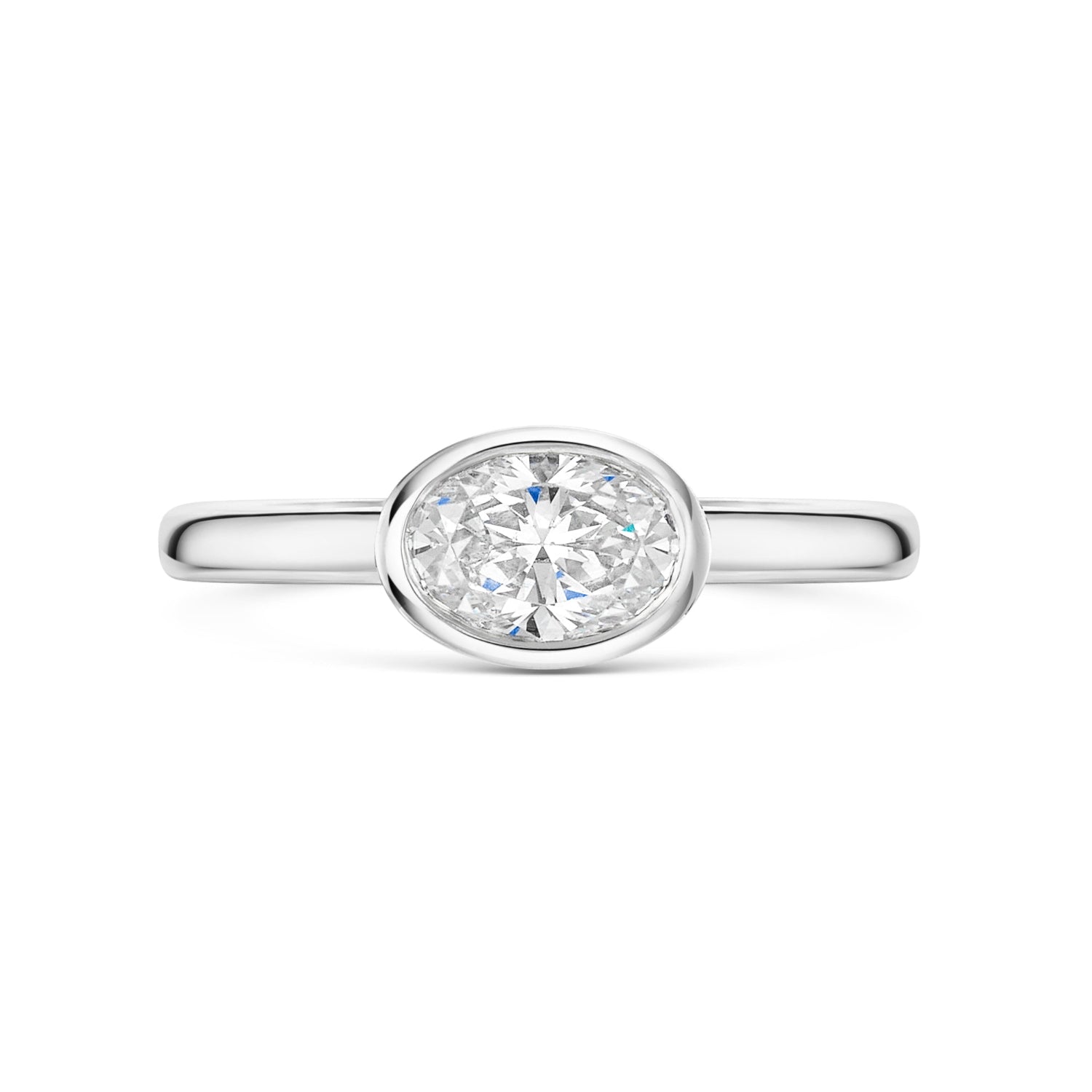 East West bezel set oval diamond solitaire in platinum on a white background 