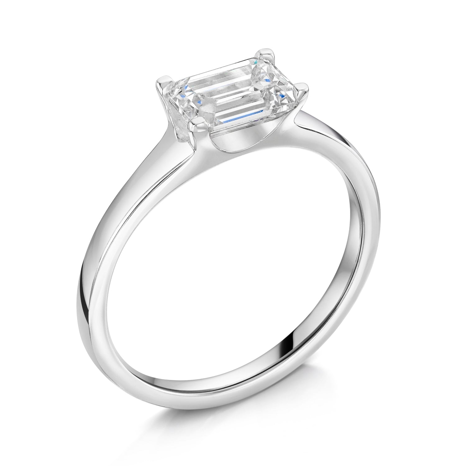 Emerald East West Diamond Engagement Ring in Platinum. Angled view on a white background