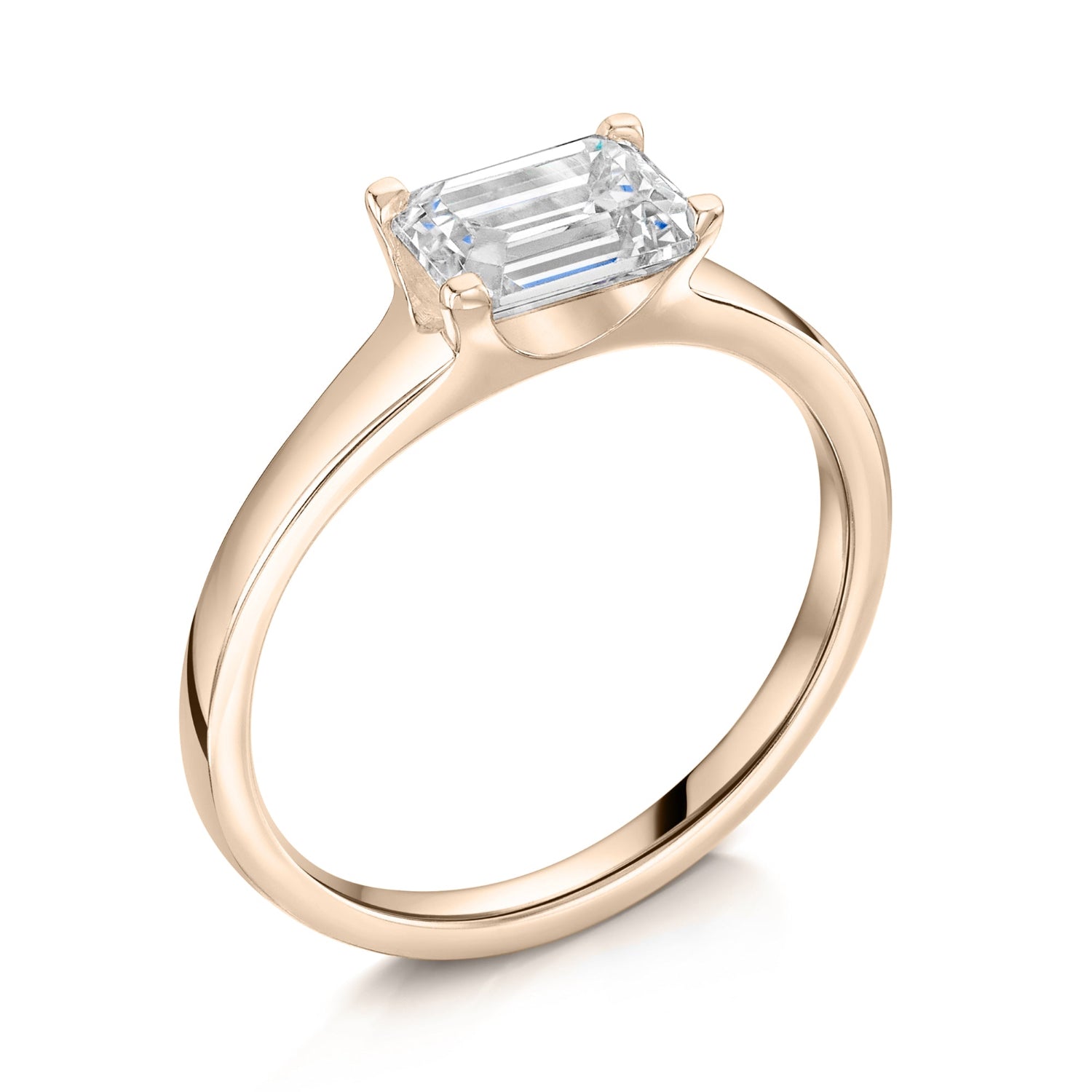 Emerald East West Diamond Engagement Ring in Rose Gold. Angled view  on a white background