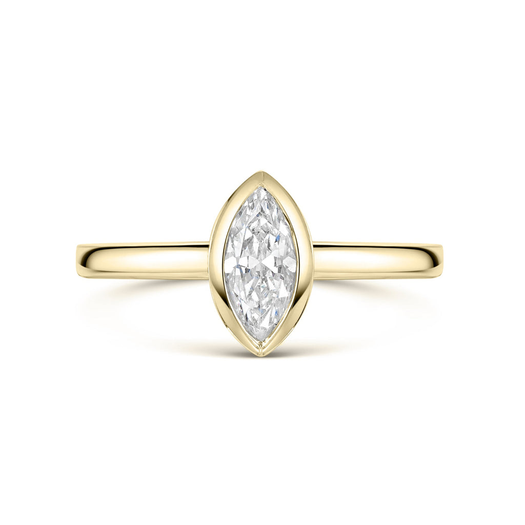 Bezel set Gold ring with a marquise-shaped diamond on a white background