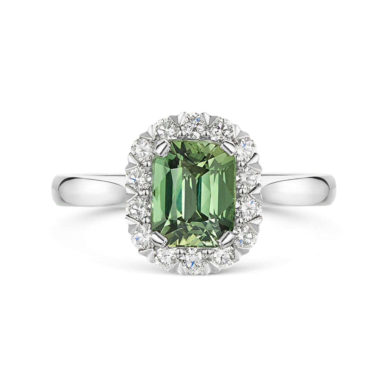 A silver ring featuring a cushion cut green sapphire surrounded by a halo of small white diamonds, set on a polished platinum band against a white background.