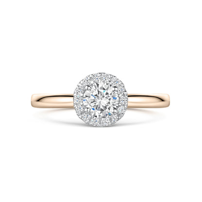 Round diamond halo engagement ring in rose gold on white background