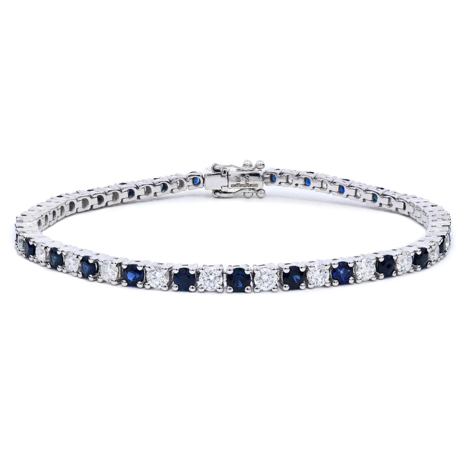 Sapphire and diamond tennis bracelet with alternating diamonds and blue sapphires in claw setting on a white background.