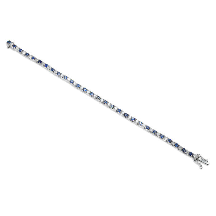 Sapphire and diamond tennis bracelet in white gold with alternating stones on a white background 