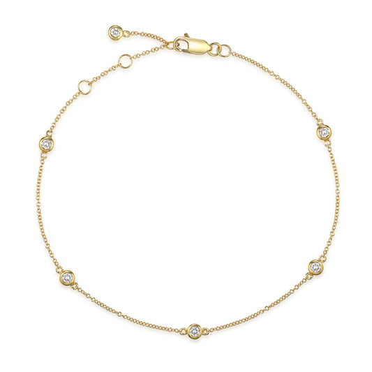 Yellow gold chain bracelet with diamonds dotted along it, on a white background 