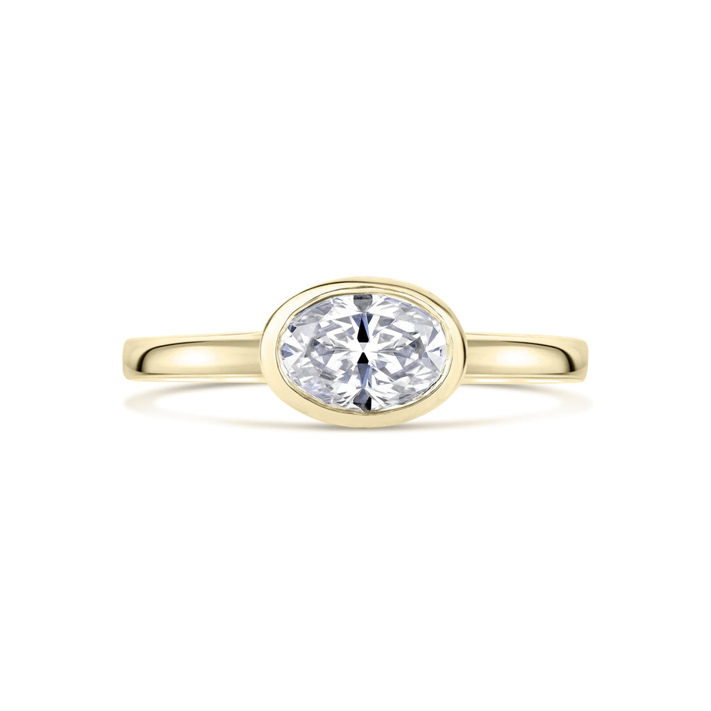Yellow Gold Oval East West Bezel Set diamond Ring on a white background