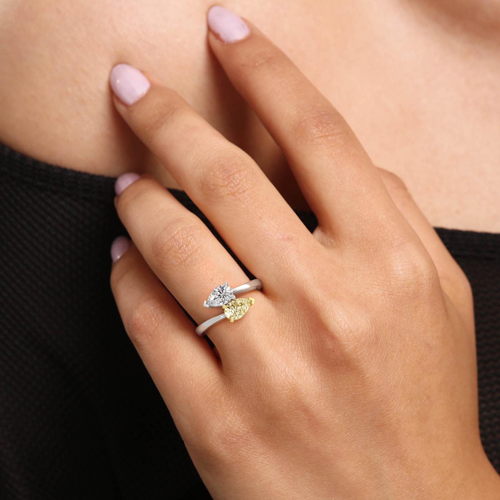 Yellow and White pear diamond 2 stone engagement ring on a models hand